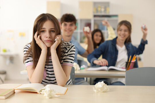 Teen problems. Students bullying their classmate in classroom, selective focus