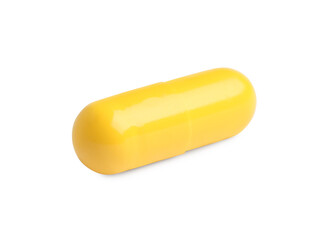 One yellow pill on white background. Medicinal treatment