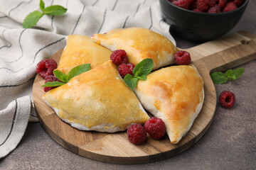Delicious samosas with raspberries on grey table, closeup