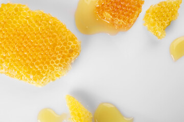 Pieces of natural honeycomb with tasty honey on white background, flat lay. Space for text