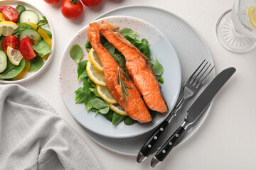 Healthy meal. Pieces of grilled salmon, spinach, lemon and rosemary served on white table, flat lay