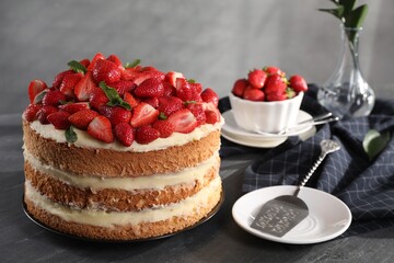 Tasty cake with fresh strawberries and mint served on gray table