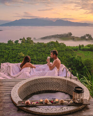 couple of men and women in a bathtub looking out over the mountains of Northern Thailand