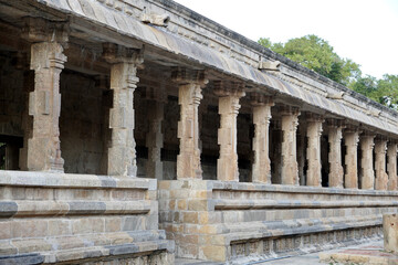 Fototapeta premium Row of pillars in ancient temple corridor. Stone Columns with Bas-relief carvings at Airavatesvara Temple, Darasuram, Kumbakonam, Tamilnadu.