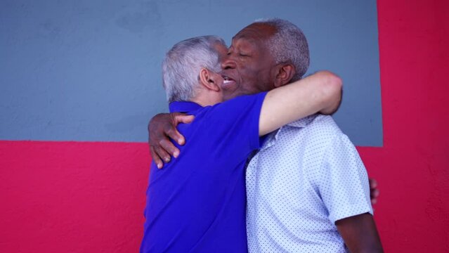 Two diverse seniors hugging each other while standing in street. A black older person embracing his caucasian friend depicting friendship in old age