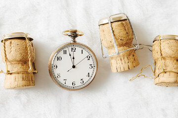 Happy New Year, xmas party concept, retro pocket watch and wine corks from festive champagne on...