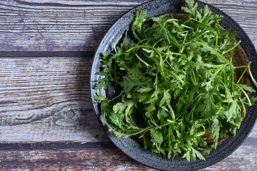 皿に盛った春菊、洗った野菜。