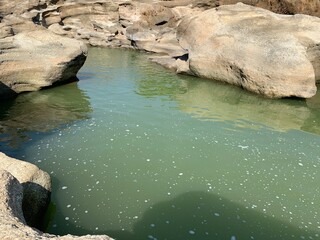 Fototapeta premium The view of the water in the dam during the dry season with its rocks is very beautiful