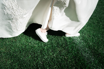 bride's feet. the bride plays football. close-up of the bride's feet in sneakers running across the...
