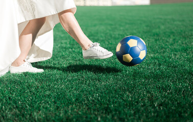 bride's feet. the bride plays football. close-up of the bride's feet in sneakers running across the football field. wedding concept