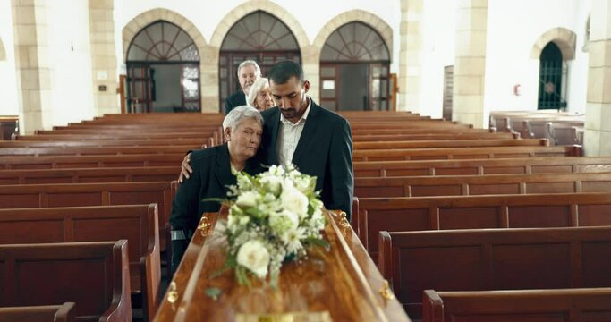 Funeral, church and people hug by coffin for goodbye, mourning and grief in memorial service. Depression, sad family and man embrace mother by casket in chapel for greeting, loss and burial for death