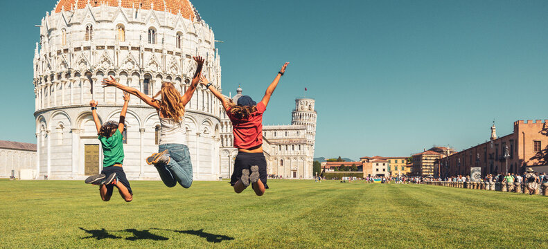 Happy family jumping in front of cathedral and leaning tower in Pisa- Travel, tour tourism, vacation in Italy