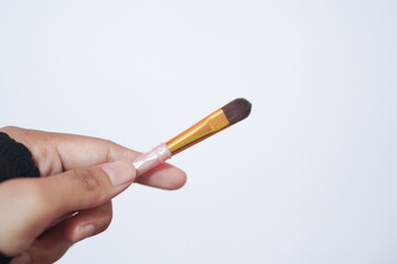 Hand model holding a a set of makeup brushes with a white background for cosmetic advertising