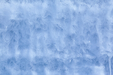 Fototapeta na wymiar Texture of winter ice on a stone cliff. Blue natural ice background