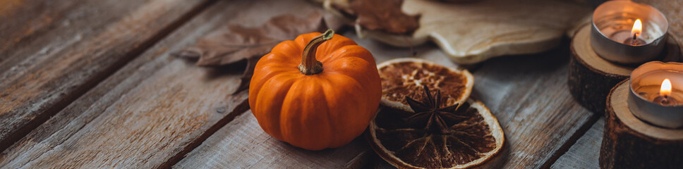 Simple home thanksgiving or halloween table decor with little orange pumpkin and other natural...