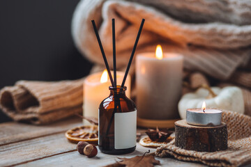 Concept of cozy fall home atmosphere, aromatherapy. Perfume, apartment aroma diffuser with autumn...
