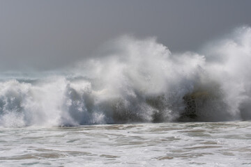Starke sich brechende Wellen / Brandung mit weißer Gischt am Meer 