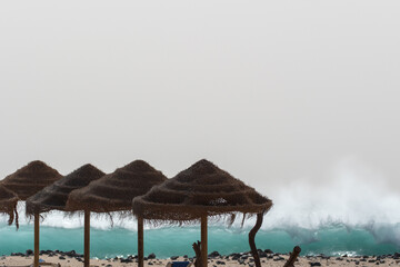 Strandhütten aus Palmen vor reißender Gischt 