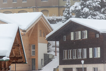 snow fall on house roof in switzerland - 673062639