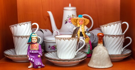 Purchased (consumer) tea set and close-up figurines on the shelf of the cabinet