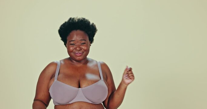 Dancing, body positivity and face of black woman in underwear in a studio for self love celebration. Happy, smile and portrait of young African female model moving with confidence by green background
