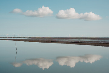 Windstille im Wattenmeer mit sich spiegelnden Wolken