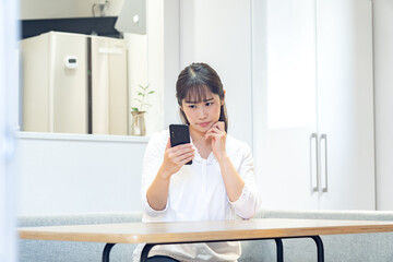 携帯を持ち悩む日本人女性