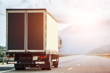 Cargo Semi Truck in the Mountains. Delivery freight truck on the Europe motorway. Global delivery concept. On the Road to Delivery