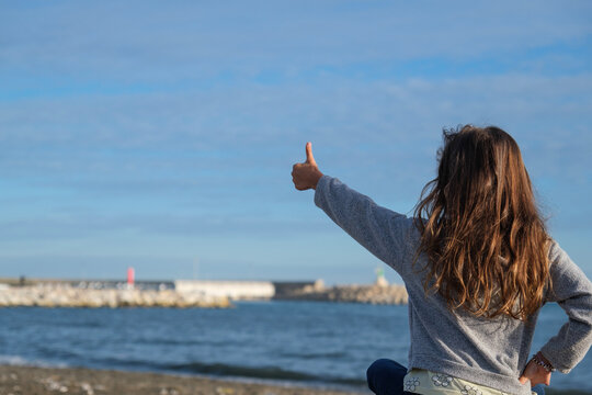Ni&ntilde;a en la playa, vista de espaldas, octubre, pelo largo suelto, jugando en la arena, 