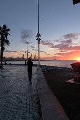 Paseo marítimo de Malaga, amanecer, primeros rayos de sol, al fondo el puerto, personas haciendo...