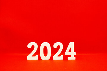 Happy New year 2024 , 2024 number wood object on red background and copy space - red color new year...