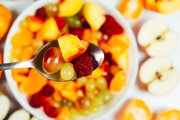 Fruit salad with nectarines, grapes and other berries and fruits, top view.