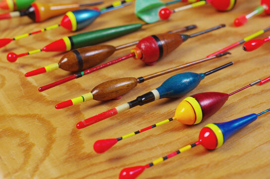 Set of colored floats for float fishing on a wooden texture background. Place for inscriptions.