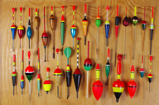 Set of colored floats for sport fishing on a wooden texture background.