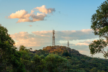 Mobile tower and power lines installation, cell site and telecom base station. 5G internet online generation.