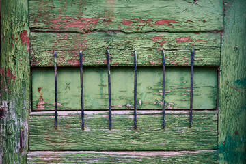 Close view of a deteriorated aged green painted wooden structure