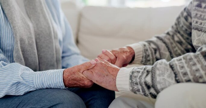 Senior, couple and holding hands for empathy, love and kindness for relationship or retirement on sofa of home. Elderly, people and comfort, connection and understanding on couch in living room