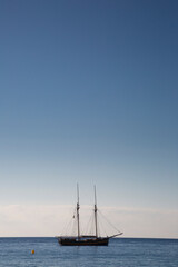 Wooden boat with two masts at anchor