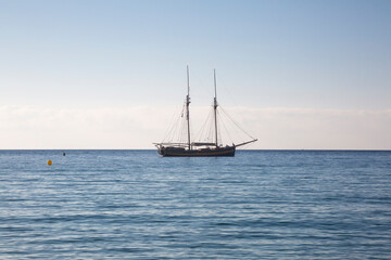 Wooden boat with two masts at anchor