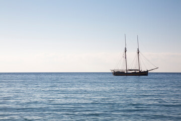 Wooden boat with two masts at anchor