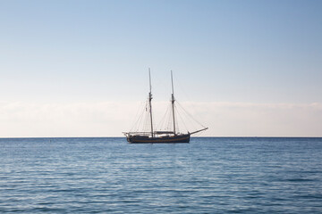Wooden boat with two masts at anchor