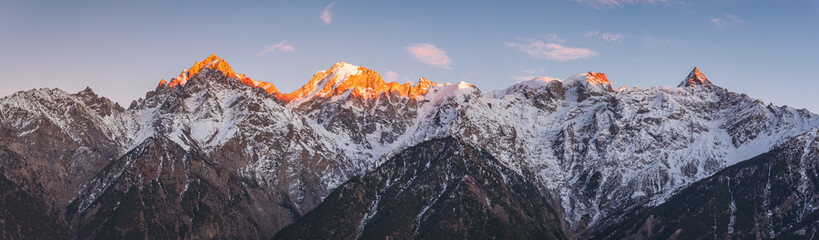 Panoramic view during sunset over snow cladded Kinner kailash mountain peaks falls in Greater Himalayas mountain range from Kalpa village, Kinnaur, Himachal Pradesh, India.