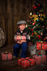 Boy under the Christmas tree with gifts. New Year