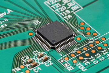 Chip in QFP package on green PCB.