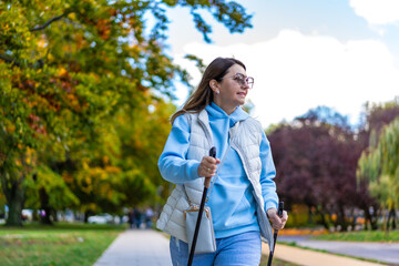 Nordic walking - mid-adult woman exercising in city park
