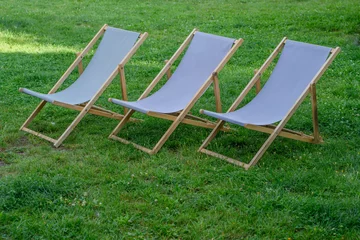Foto op Canvas Stare drewniane leżaki plażowe na trawniku w ogrodzie  © Paweł Kacperek