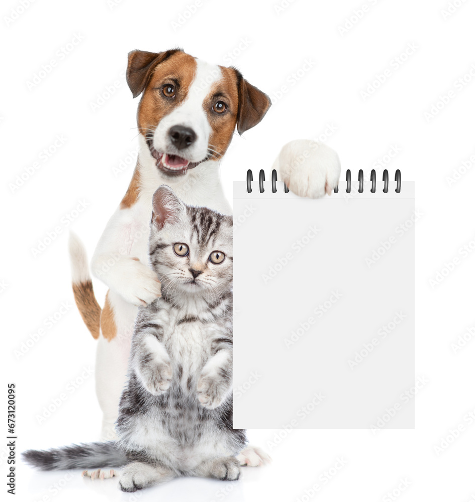 Poster smart jack russell terrier puppy hugs tabby kitten and shows empty list. isolated on white backgroun