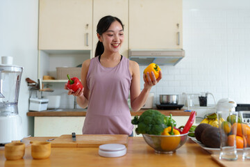 Beautiful young woman in exercise clothes preparing vegetable salad in the kitchen, healthy food Vegetarian salads, ideas, fasting, food selection, healthy lifestyle, cooking at home.