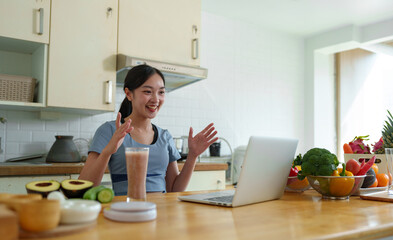 Young Asian woman live chatting, video calling on laptop computer, how to lose weight with diet. Introducing useful fruits and vegetables Lifestyle Influencer Healthy concept, lifestyle.