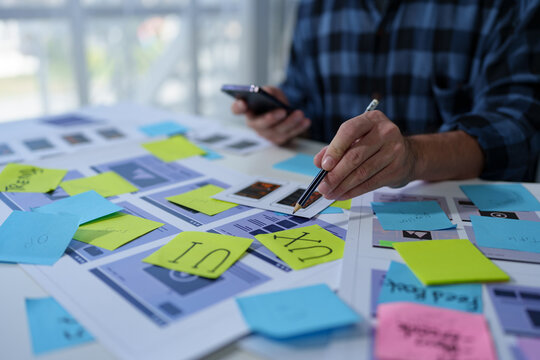 UX developers and UI designers spend more thought planning on mobile app interface design wireframe interface on desk at office creative digital concept.